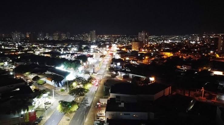 Fios de rede elétrica contra o céu, com pipa colorida presa próxima aos cabos de energia.