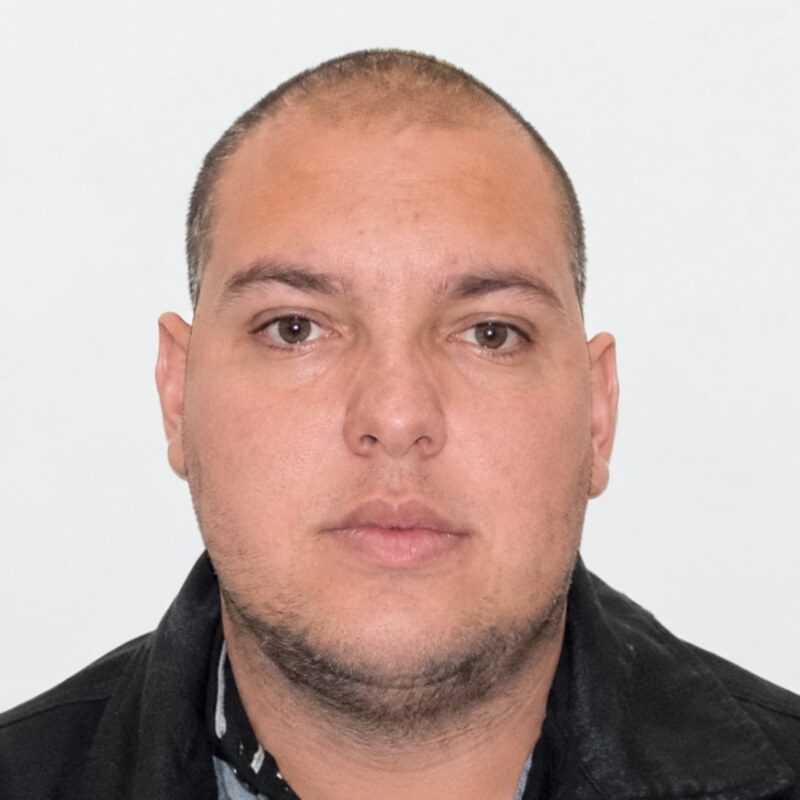 Viaturas da Polícia Militar com as luzes acesas em um cruzamento à noite, com o asfalto molhado