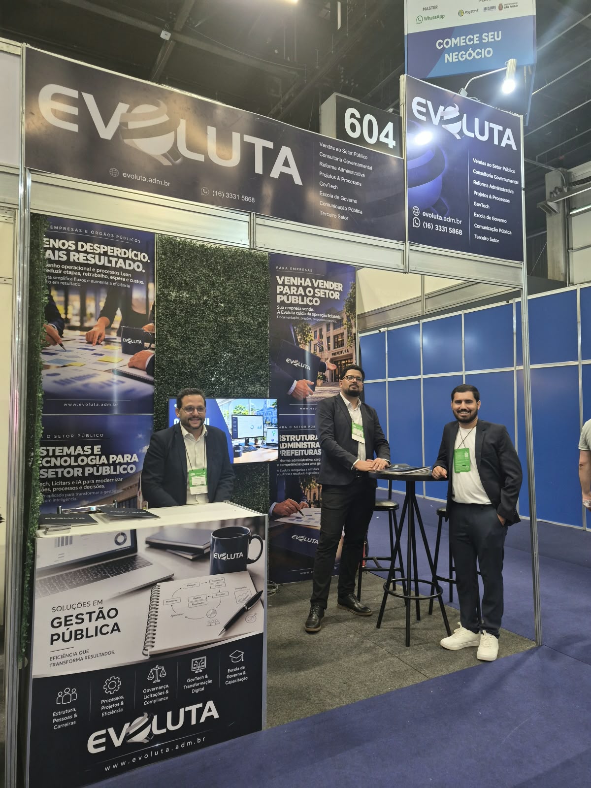 Estande de empresa de consultoria em gestão pública na Feira do Empreendedor, com consultores conversando com visitantes
