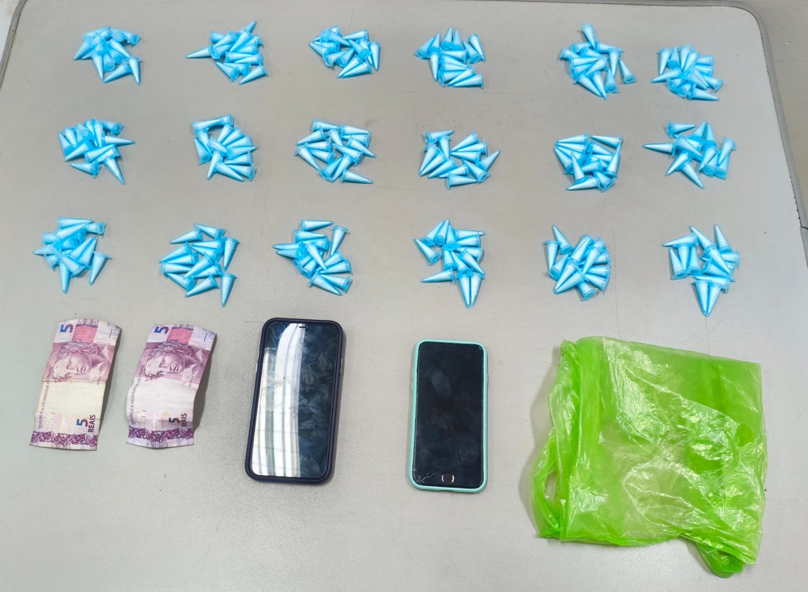 Garagem com 234 microtubos de cocaína apreendidos pela GCM em Araraquara, no Jardim São Rafael; duas pessoas em frente à casa.